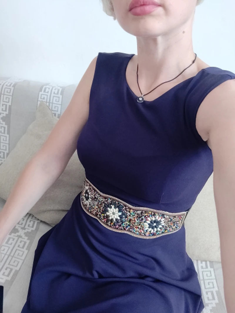Woman in navy dress wearing boho flower waist belt for women embroidered with multicolour beads and floral motifs