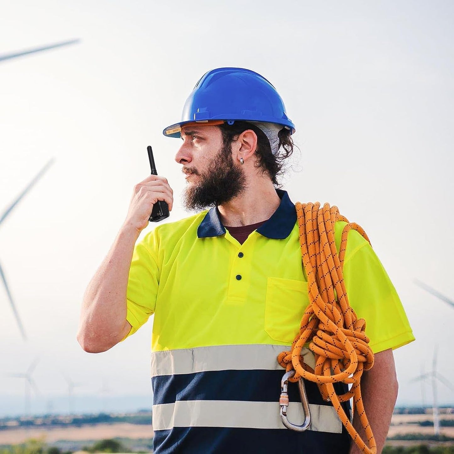 Construction worker using BAOFENG BF-88ST Pro with earpieces walkie talkie outdoors with safety gear