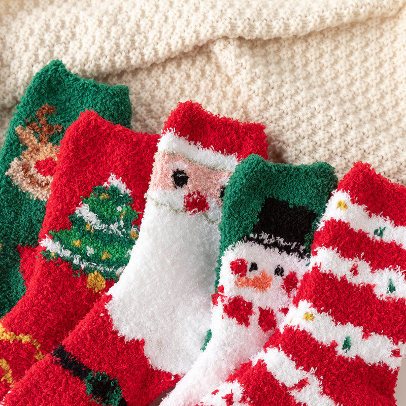 Festive fuzzy Christmas socks with Santa snowman tree and reindeer designs on a cream blanket thick winter home socks for children