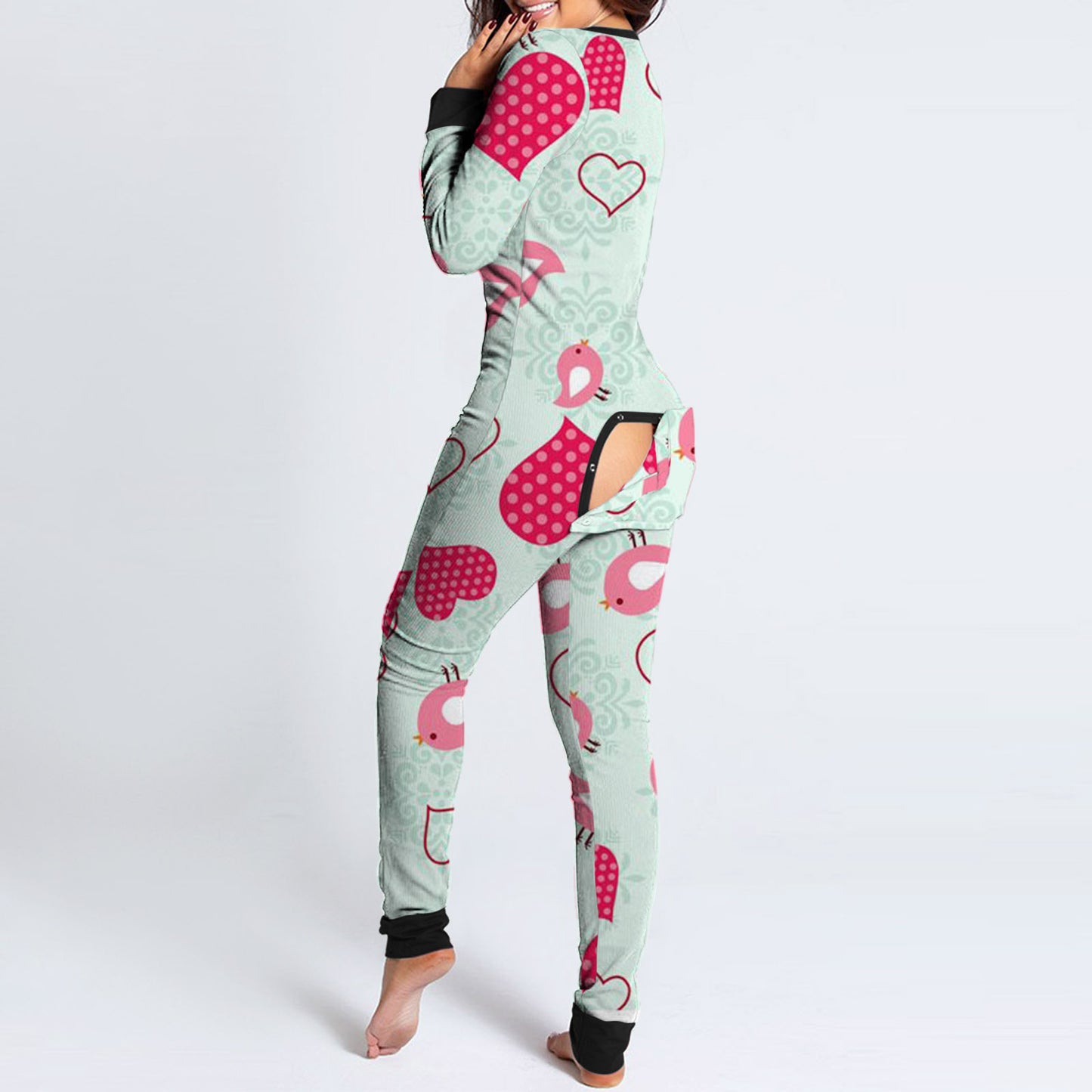 Woman modelling mint heart and bird print onesie with black cuffs open rear buttoned flap fun buttoned flap overalls sleep suit