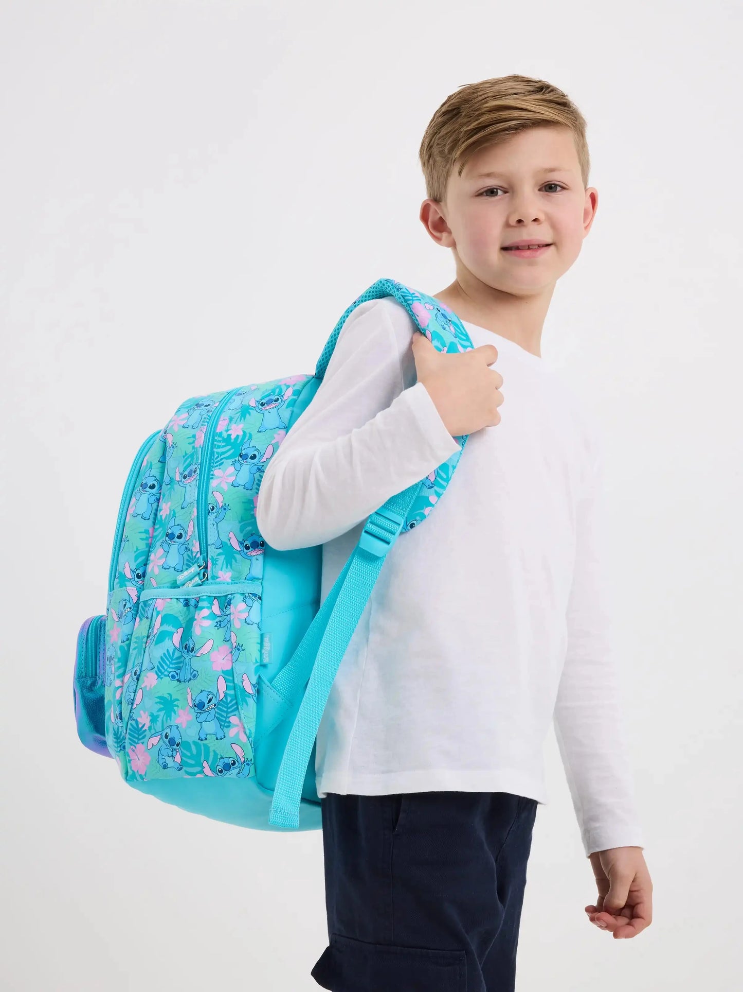 Young boy modelling turquoise patterned backpack from Smiggle school bag set for girls by Luxurymania24
