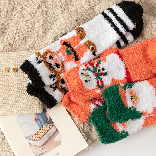 Set of three Coral Fleece Christmas Socks in orange white and green with festive Santa and snowman designs