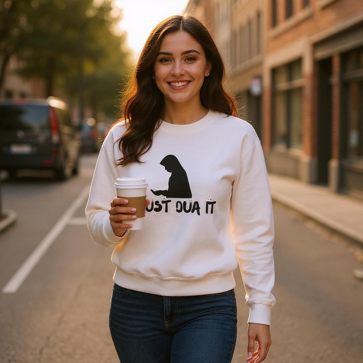 Woman wearing classic unisex pullover hoodie with Just Dua It print holding coffee cup outdoors