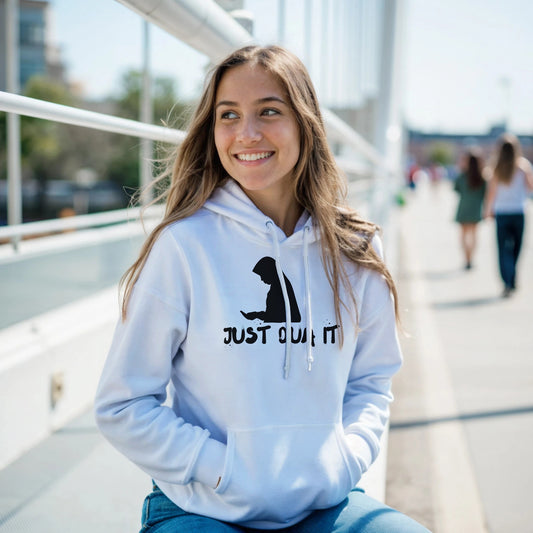 Smiling woman wearing a unisex white pullover hoodie with Just Do It graphic sitting outdoors