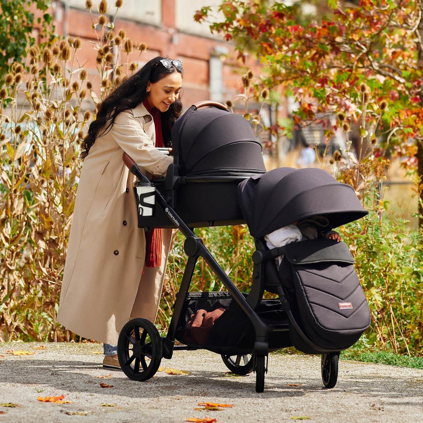 Luxurymania Ickle Bubba Virgo Twin travel system black double stroller with woman outside