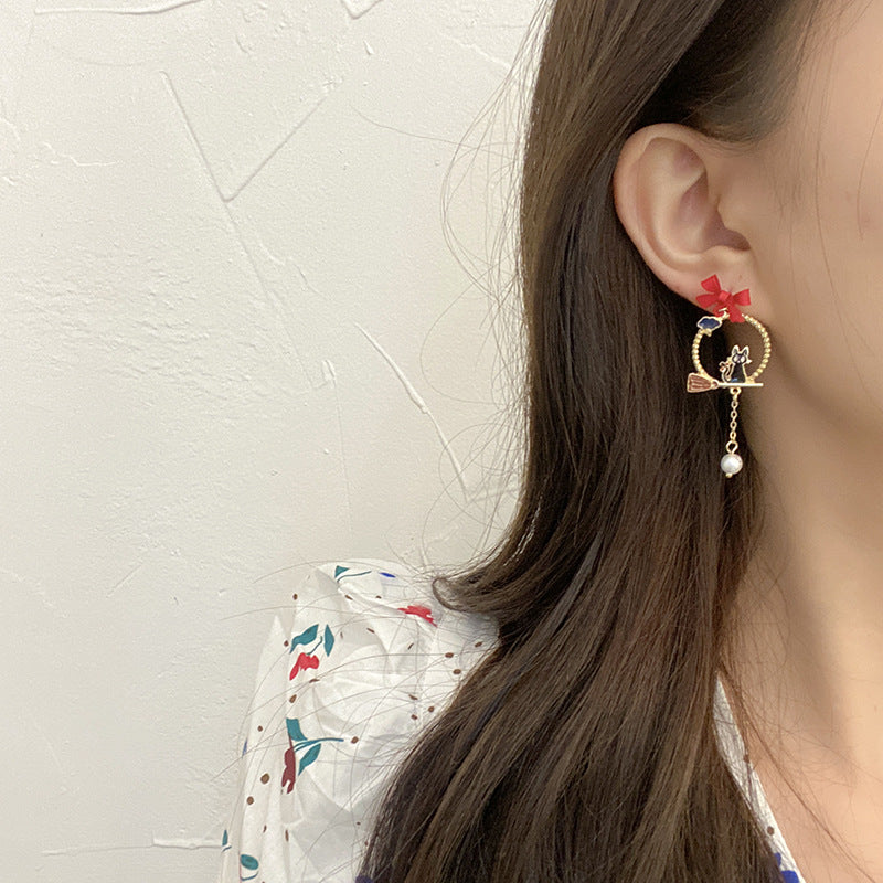 Creative Drip Oil Bow Earrings worn on ear gold hoop with red bow charm cat detail and dangling pearl