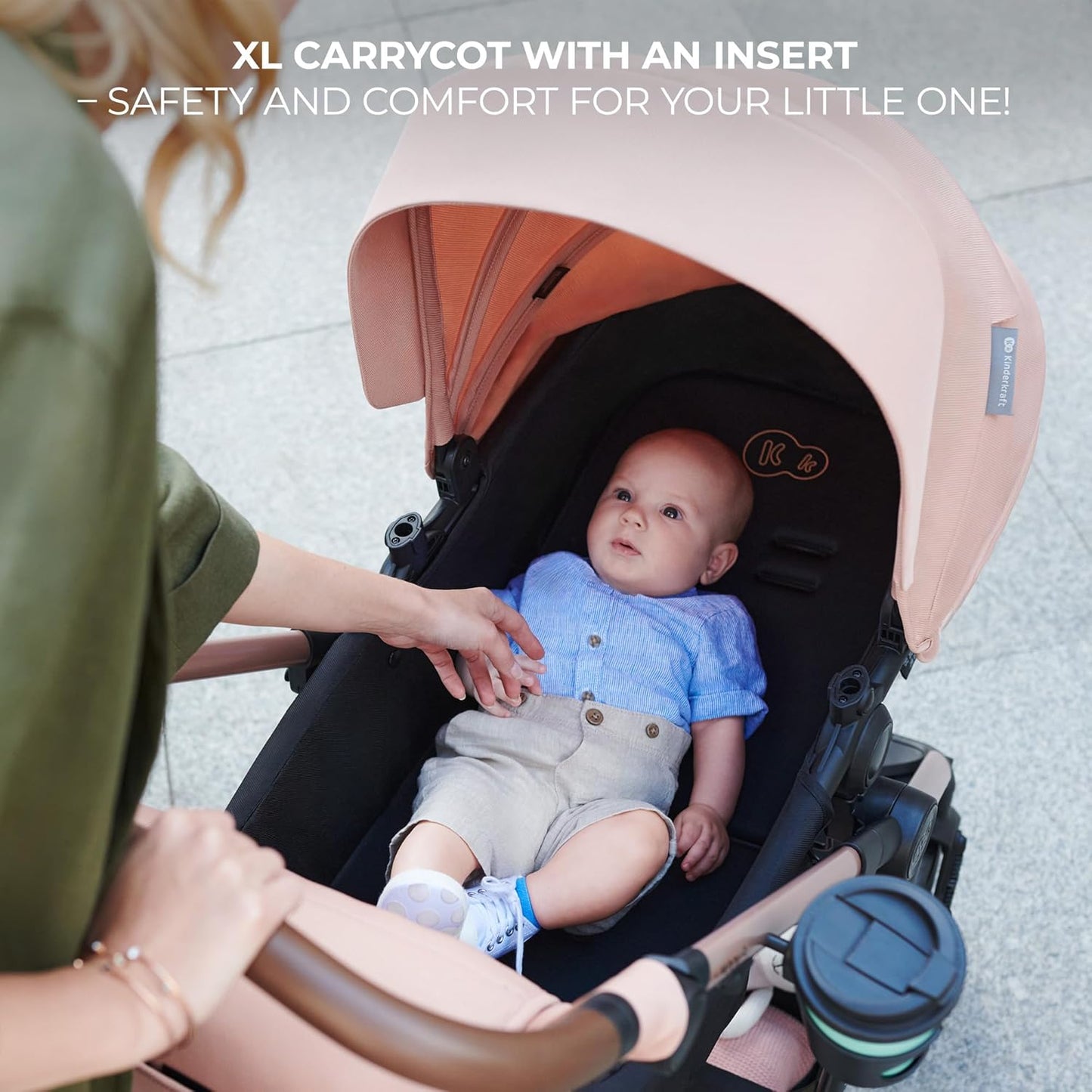 Kinderkraft MOOV2 AIR pram set with peach canopy and XL carrycot insert showing baby and parent hand