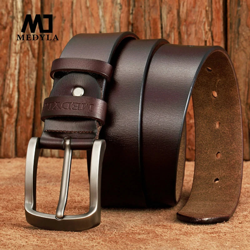 MEDYLA Leather Strap For Men brown full grain leather belt with metal buckle and embossed logo on wood background