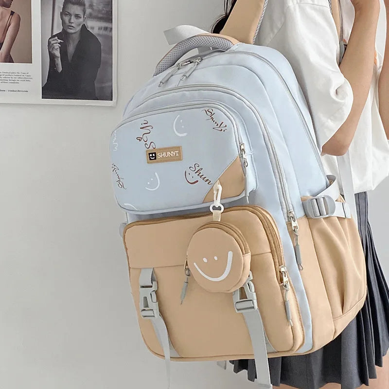 Light blue and beige primary school backpack for girls with smiley coin pouch and multiple compartments