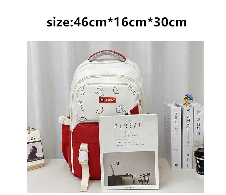 White and red backpack with smiley doodle and front pocket primary school backpack for girls 46 by 16 by 30 cm
