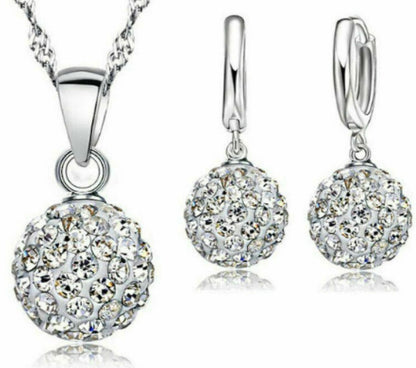 Silver jewelry set with round crystal pendants on a white background