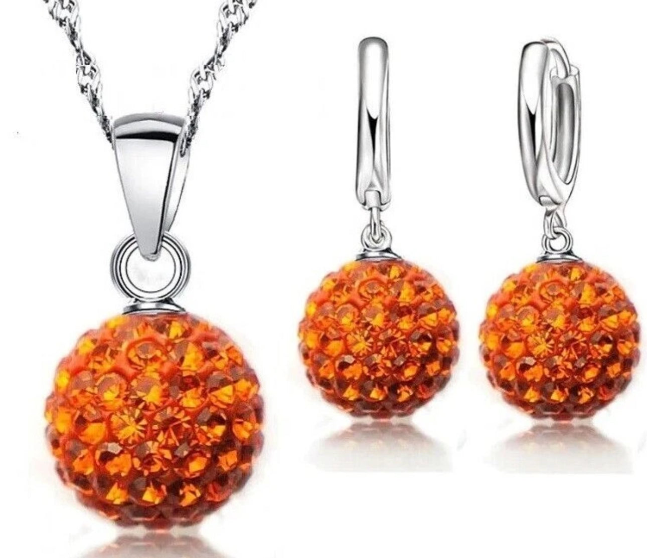 Jewelry set with orange spherical pendants on a white background