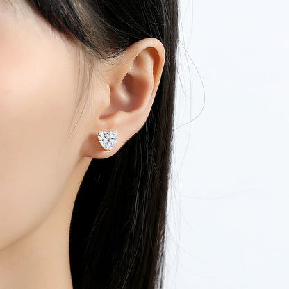 Heart-shaped diamond earring worn by a model on a white background