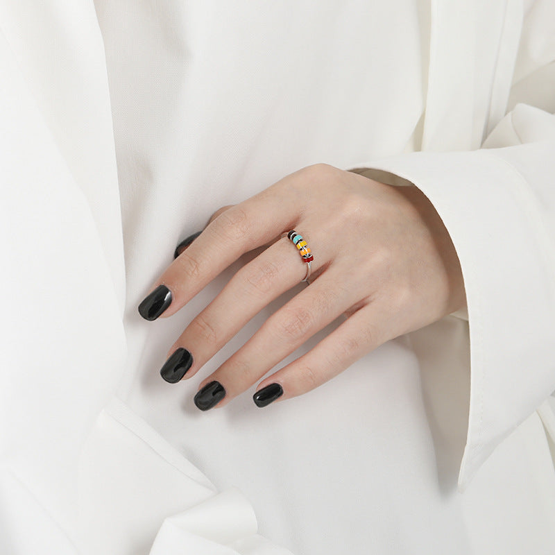 Hand model wearing European Style Drip Oil Ring with multicolour enamel beads on slender finger over white blouse