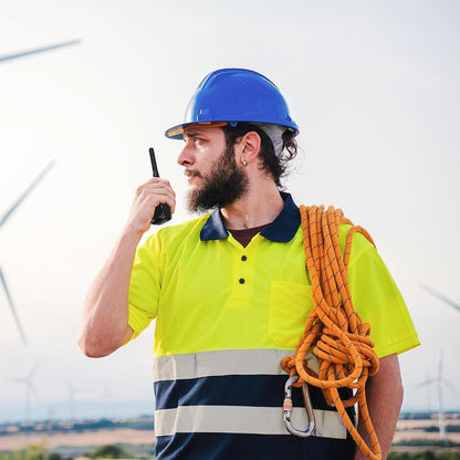 Construction worker using BAOFENG BF-88ST Pro with earpieces walkie talkie outdoors with safety gear