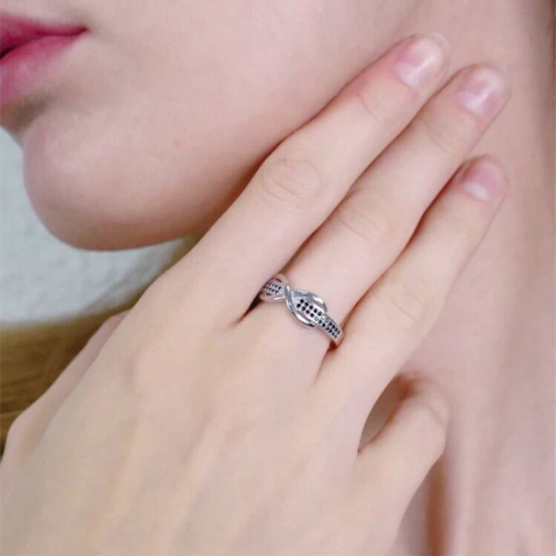 Elegant silver engagement ring for women with a unique twisted design displayed on a hand