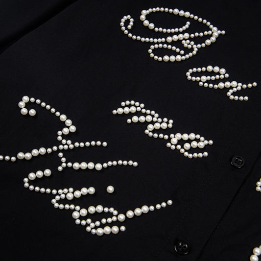 Close up of black button shirt with pearl script embellishments street style beaded shirt for casual or evening wear