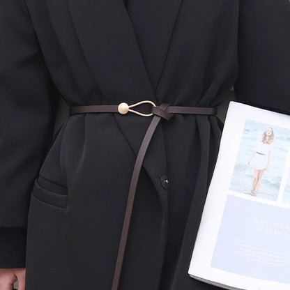 Ladies Carved Metal Buckle Leather Belt slim brown waist belt with carved metal buckle worn over black coat