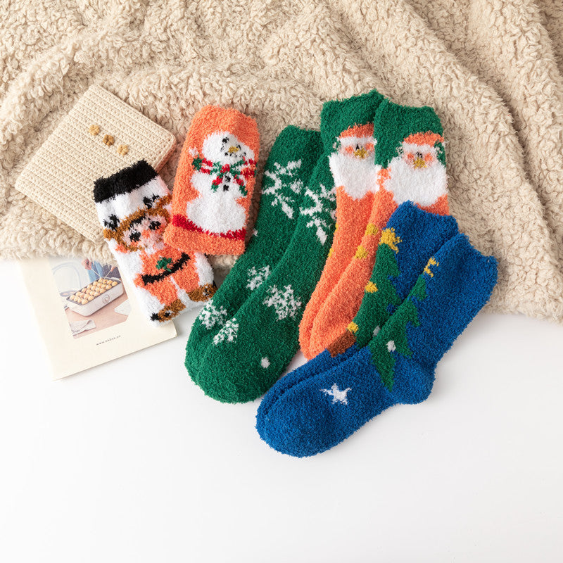 Coral Fleece Christmas Socks set with Santa snowman fox and snowflake patterns on cosy beige blanket