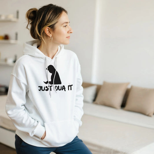 Unisex white pullover hoodie with black Just Dua It print worn by woman indoors