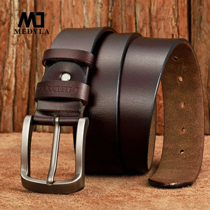 MEDYLA Leather Strap For Men brown full grain leather belt with metal buckle and embossed logo on wood background