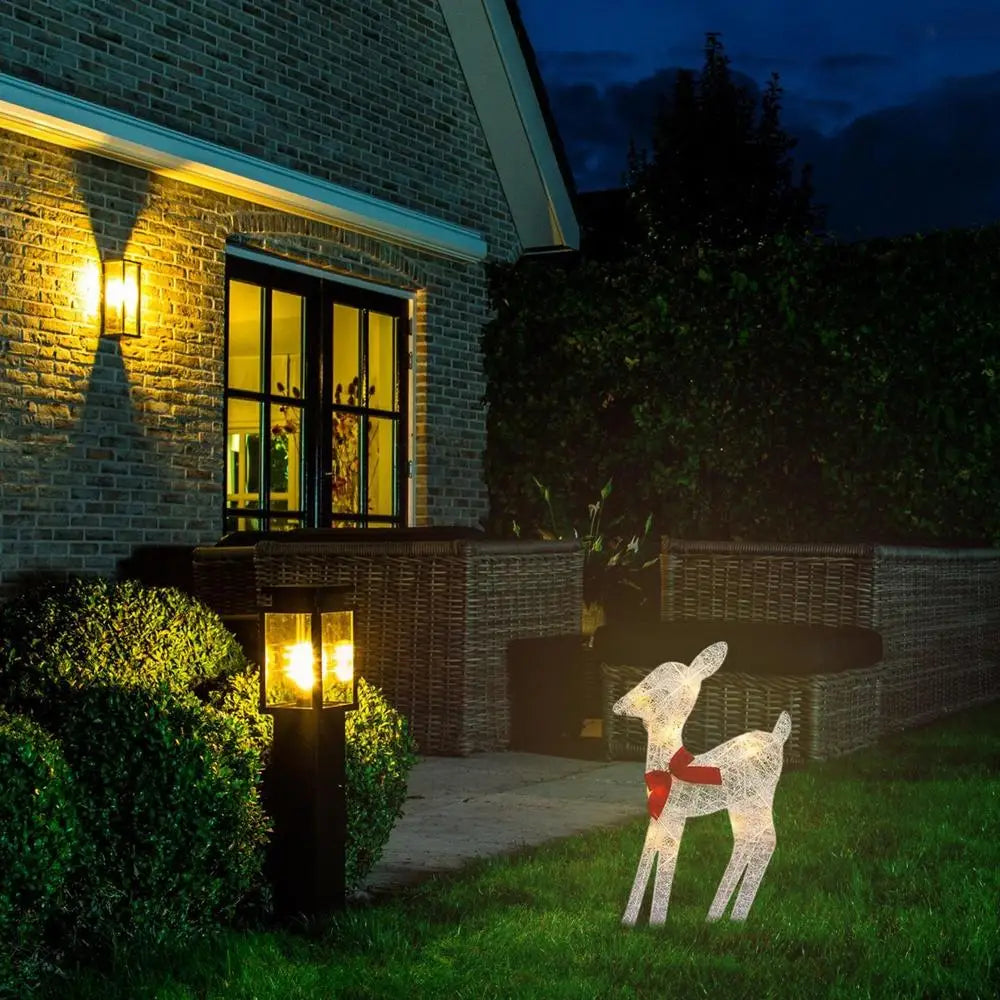 Outdoor glowing elk Christmas ornament placed in garden beside a house, radiating festive charm at night