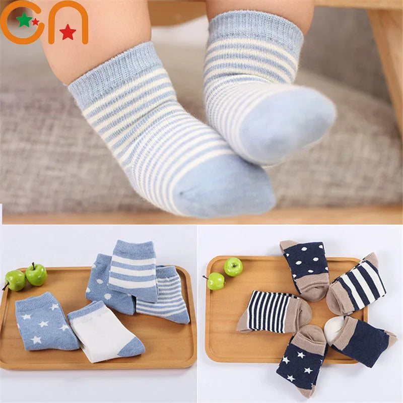 Soft toddler socks for boys and girls in various colours and patterns on a wooden tray