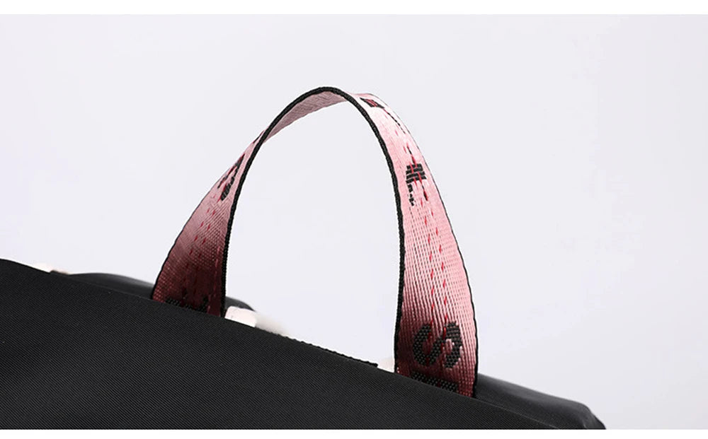 Pink Black Laptop Backpack For Students top carry handle close up showing pink patterned webbing strap on black bag