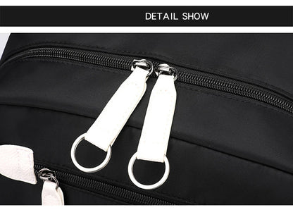 Pink Black Laptop Backpack For Students close up of black backpack zipper detail with white pink pull tabs and metal rings